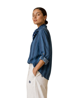 Ronan Striped Chambray Button-Down in blue, side view showing the tabbed rolled sleeve