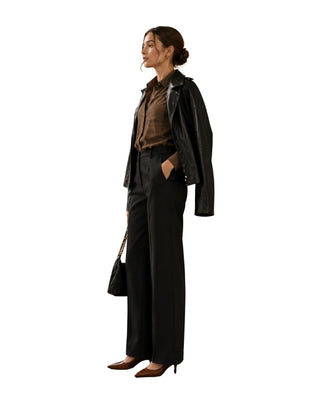 Scarlett High Collar Leather Jacket in black, side view worn over the shoulders with a black handbag