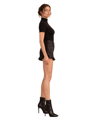 Pleather Ruffle Short in black, side view worn with ribbed top and heeled ankle boots