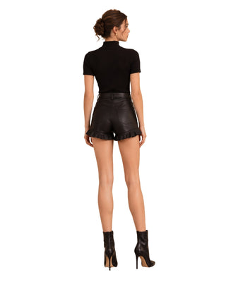 Pleather Ruffle Short in black, back view worn with ribbed top and heeled ankle boots