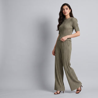 Woman in a sage pleated top and matching wide-leg trousers