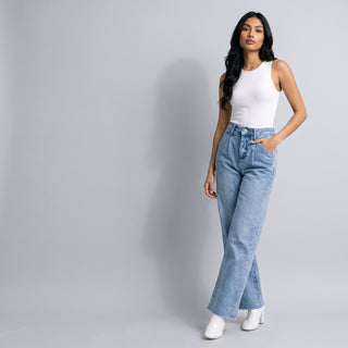 Woman in a white tank and light-wash wide-leg jeans